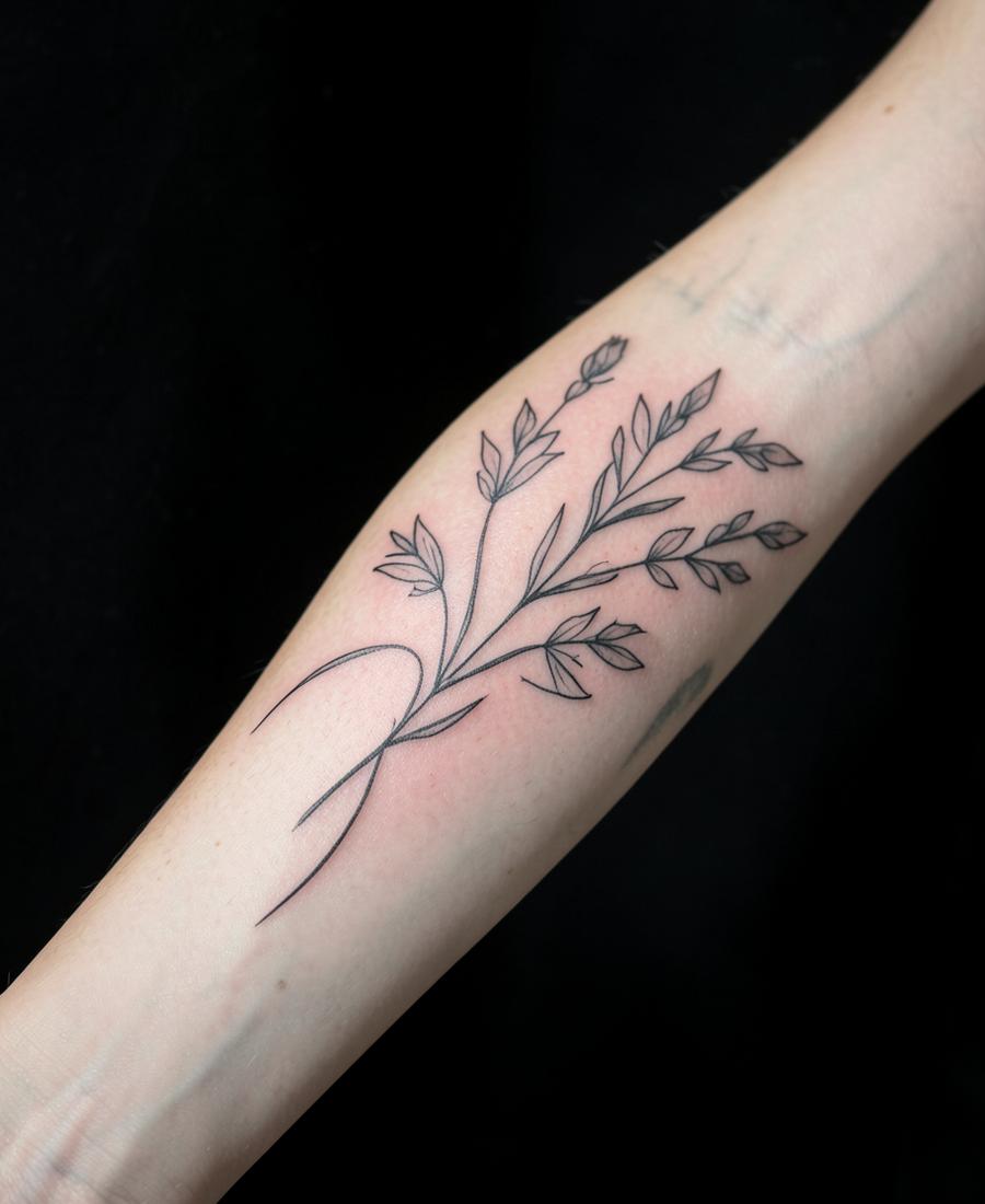 Tatuaje de línea fina botánico en el antebrazo